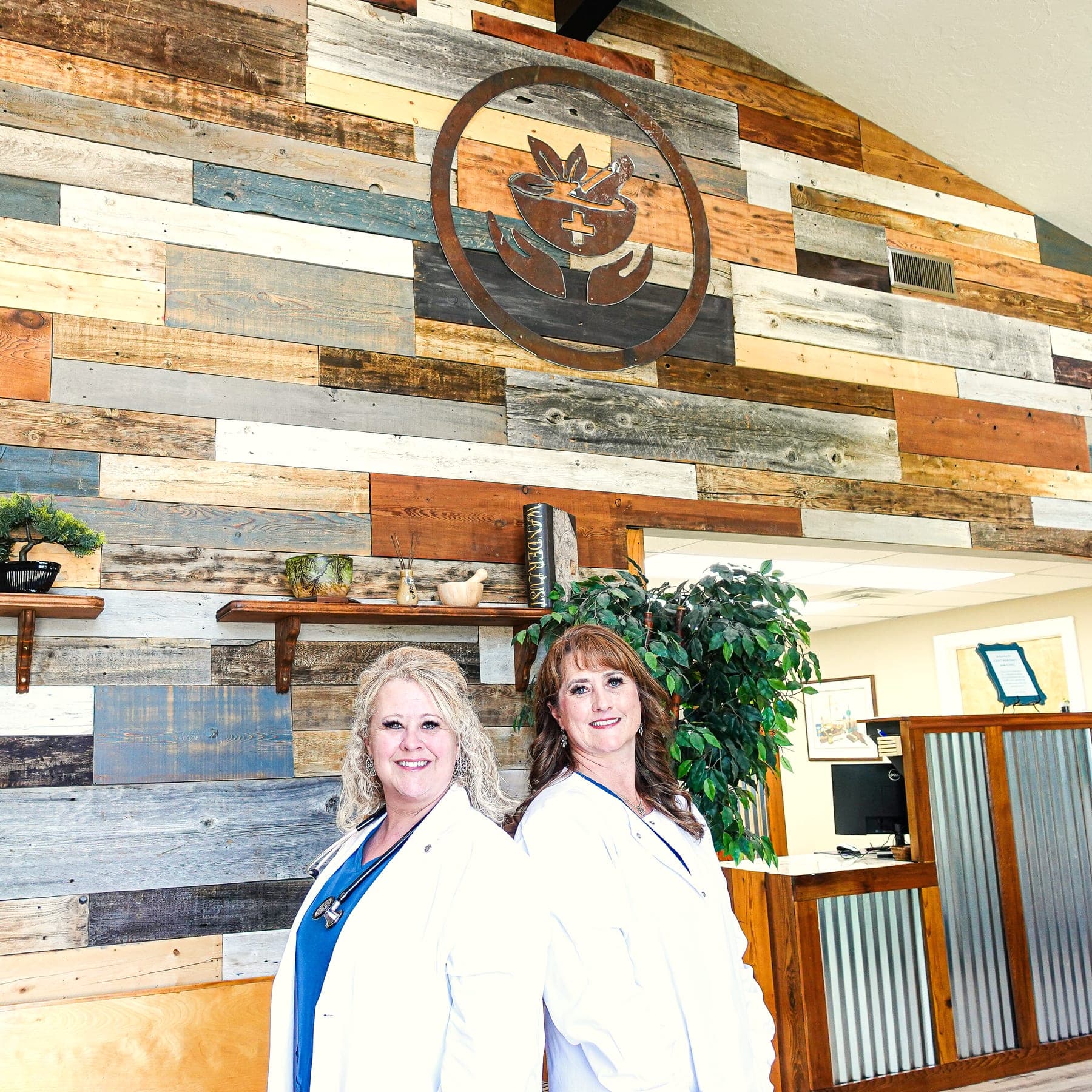Toni Cantrell and Heidi Winder in the front room of Craft Pharmacy & Clinic, beneath the mortar-and-pestle sign on the reclaimed-wood wall
